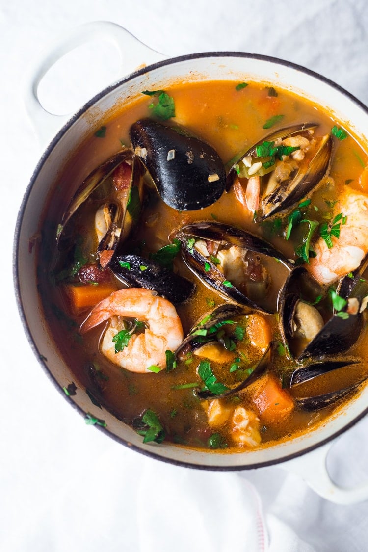A simple authentic Cioppino Recipe that is easy to make and full of flavor. Fresh fish and seafood in a flavorful light broth. Serve with crusty bread to mop up all the juices. #cioppino #seafoodstew #fishstew #fishermansstew #italianstew #cioppinorecipe