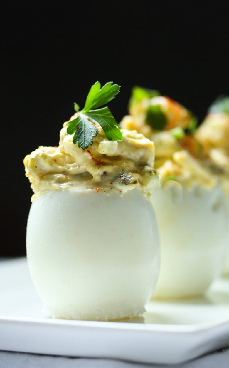 The Best EVER Deviled Eggs- Made with crumbled bacon ( or vegan bacon bits) cheddar and onion, simple and soooooo delicious! | #deviledeggs www.feastingathome.com #appetizer #partyappetizer