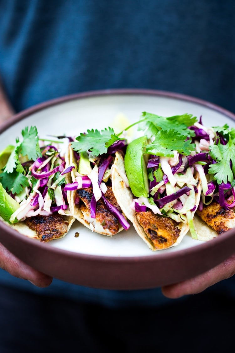 Simple tasty Grilled Fish Tacos with a delicious Cilantro Lime Cabbage Slaw- a "go-to" healthy dinner that be made in 30 minutes flat. | www.feastingathome.com #slaw #fishtacos #tacos #cabbageslaw