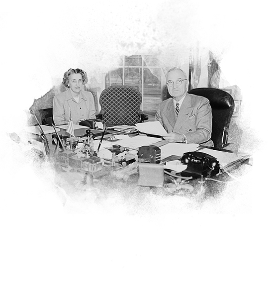 President Truman and his secretary at the President's desk in the Oval Office signing the National Security Act