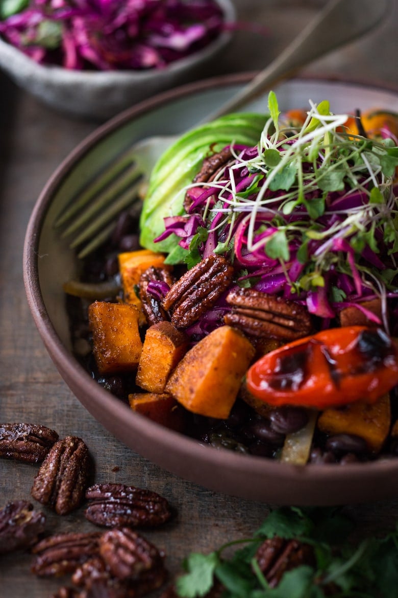 40 Mouthwatering Vegan Dinners!| Mexican-style Oaxacan Bowl with roasted chipotle sweet potatoes and sweet peppers over a bed of warm seasoned black beans. It’s topped with a crunchy cabbage slaw, avocado and my favorite thing ever, toasted Chipotle Maple Pecans. Vegan and grain-free, hands down, this bowl is my new favorite!