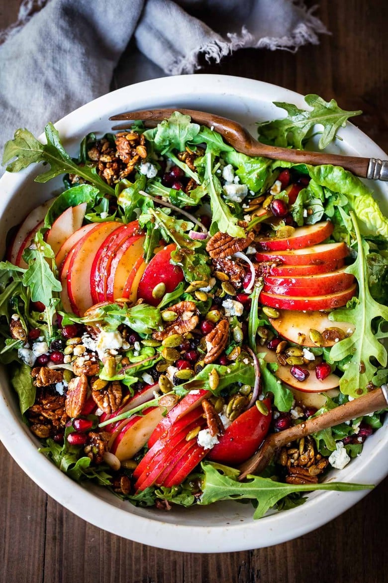 This Pear Salad Recipe is bursting with flavor. Juicy ripe pears, spicy nutty arugula, spiced maple-glazed seeds and pecans, pomegranate seeds, dried currants and gorgonzola cheese are all tossed in a flavorful Vanilla Fig Dressing to create the most delicious balance of flavors.