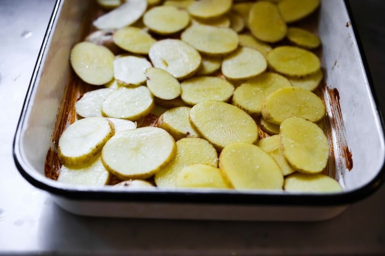 potatoes layered over the marinade