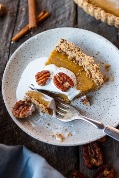 A decadent Vegan Pumpkin Tart with a smooth caramely pumpkin filling in a tender pecan oat crumb crust. Richly spiced, easy to make, and freezes beautifully. Perfect for the holidays!