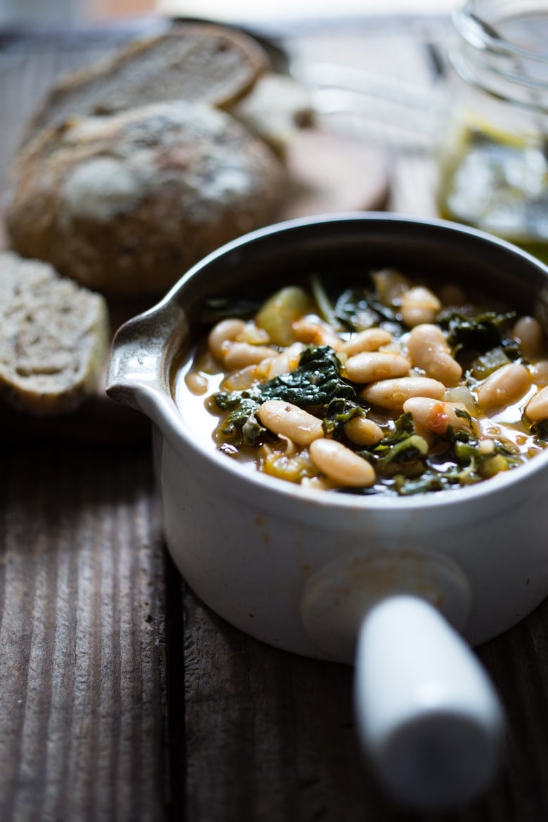 30 Comfort Food Recipes for Fall! A flavorful hearty stew from Tuscany, called Ribollita with Cannellini beans, lacinato kale, and vegetables, served with crusty bread, drizzled with a Lemon Rosemary Garlic Oil. | www.feastingathome.com