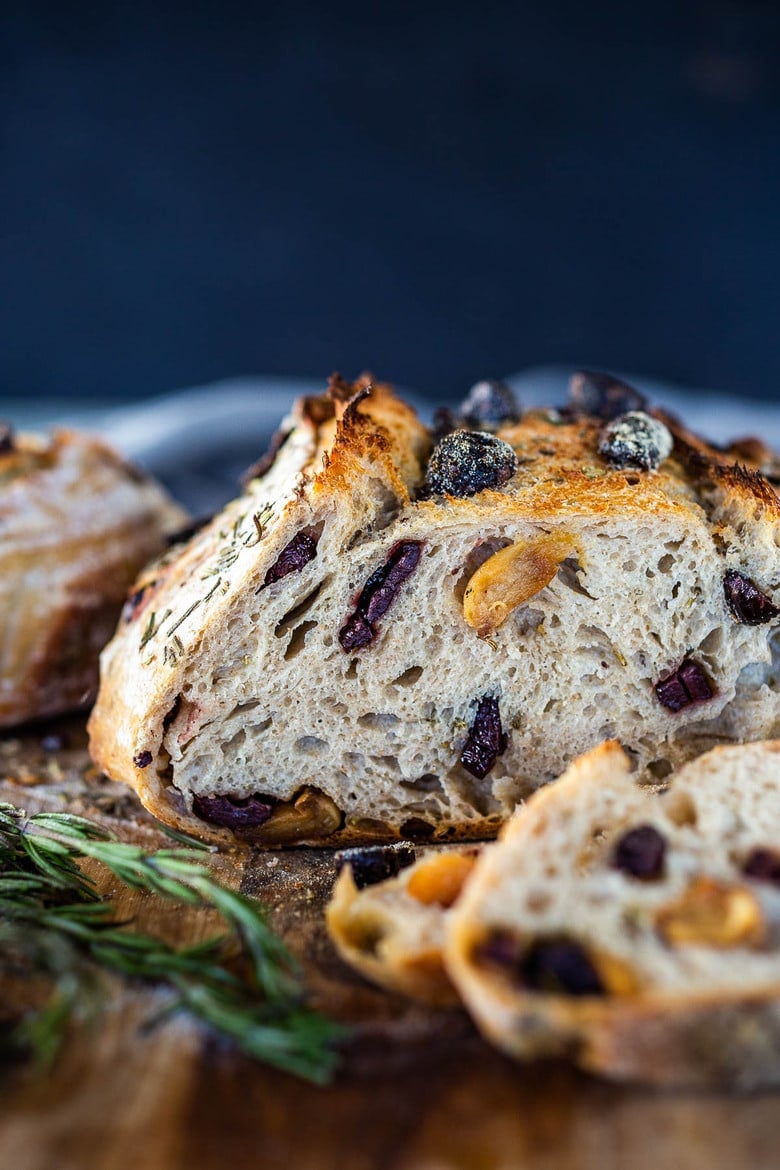 How to make Rosemary Olive Sourdough Bread with whole roasted garlic that requires no kneading and rises overnight. 