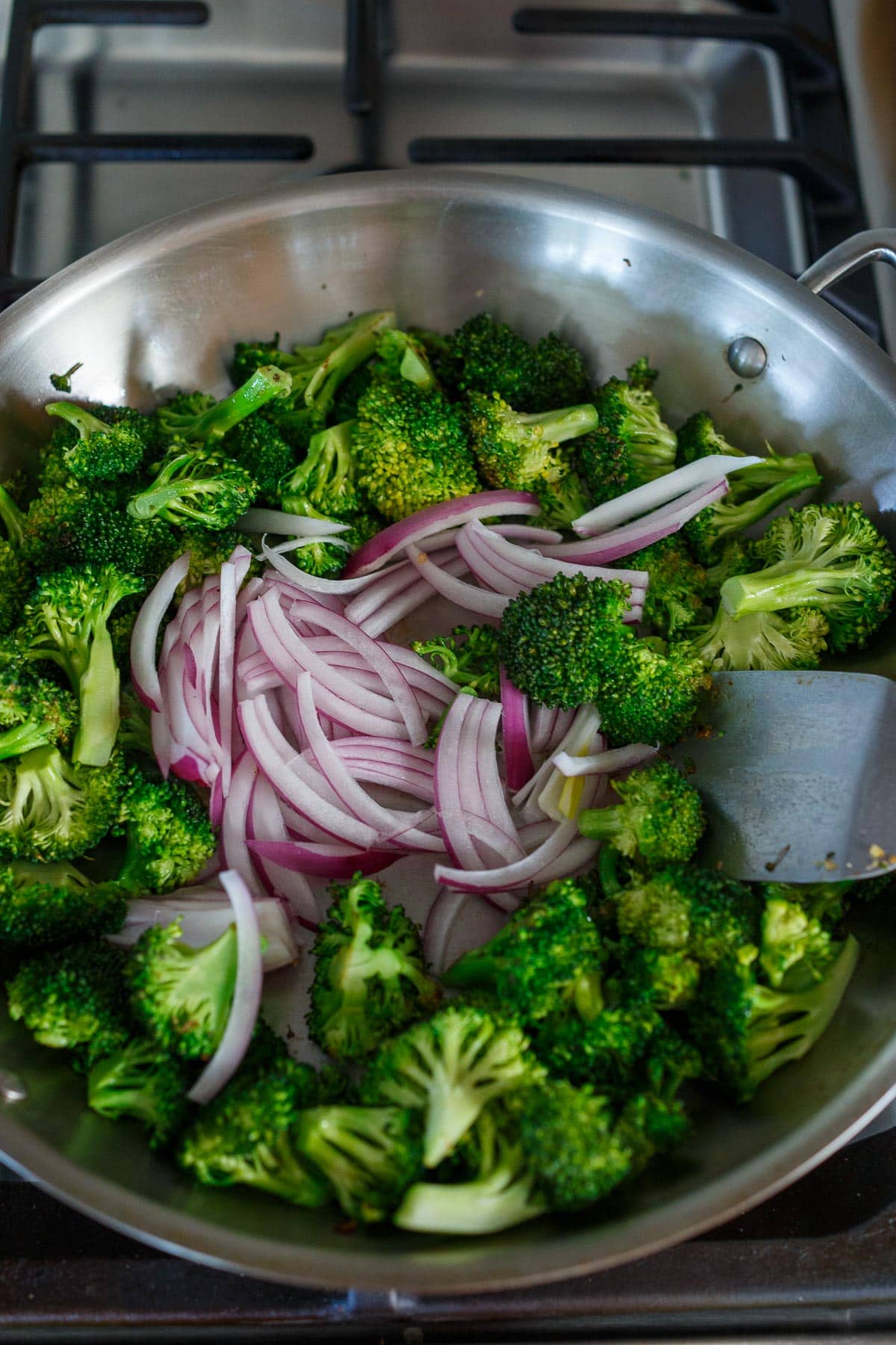 Broccoli and red onions in sauté pan.