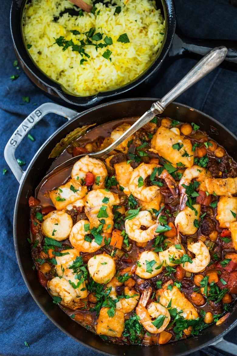 Spanish Seafood Stew with Garbanzo beans and Chorizo served over Saffron-infused rice. | #spanishstew #seafoodstew #shrimp #seafood #stew www.feastingathome.com