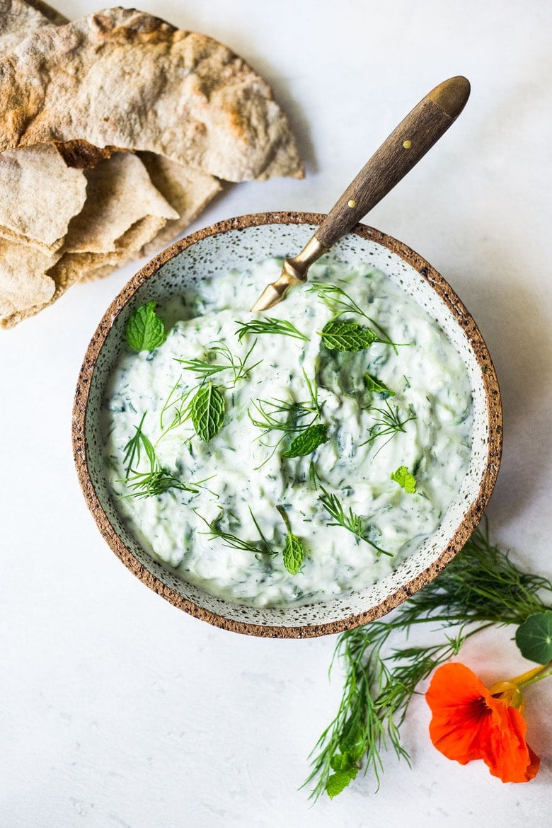 The BEST Tzatziki Sauce! An easy, healthy, Greek cucumber-yogurt sauce to use in mezze platters, wraps, gyros, or as a simple dip for pita, or as a delightful side to Mediterranean dishes. This SIMPLE recipe can be made in 15 minutes! #tzatziki #tzatzikirecipe #tzatzikisauce #easy #cucumbersalad 